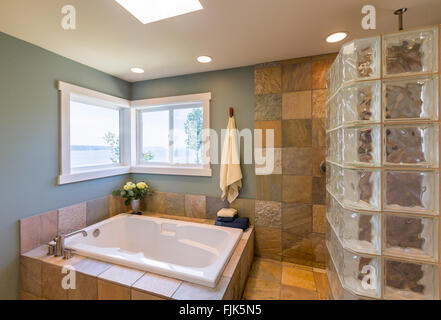 Contemporaneo ed elegante home spa bagno interno con vetro doccia piastrelle di ardesia, pareti di piastrelle, acrilico vasca da bagno e finestre di visualizzazione Foto Stock