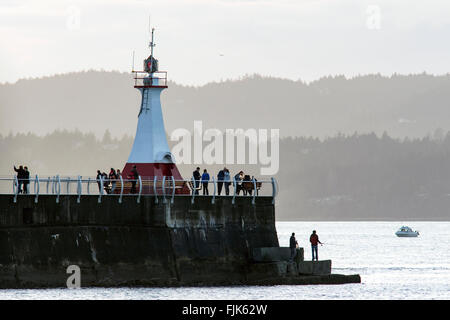 La gente che camminava sul frangiflutti a Ogden Point - Victoria, Isola di Vancouver, British Columbia, Canada Foto Stock