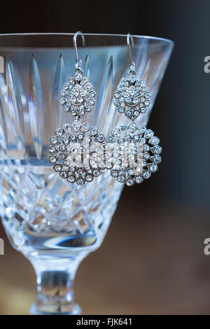 Fancy, ornato di strass Orecchini diamante pendente dal labbro di un taglio sottile cristallo al piombo bicchiere di vino. Costoso, preziosi beni di lusso. Foto Stock