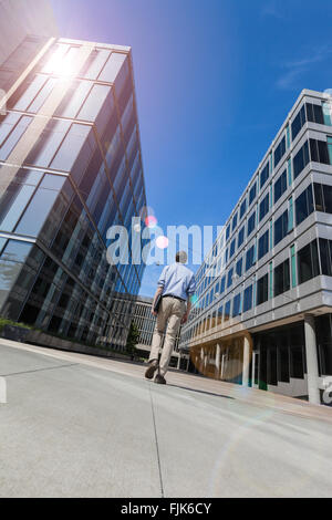 Vista posteriore dell'uomo lavoratore professionale a piedi verso uffici moderni edifici. Il successo, lavori di tech, forza lavoro, realizzazione di concetti. Foto Stock