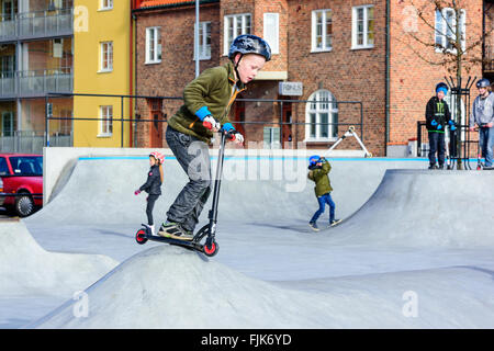 Solvesborg, Svezia - 27 Febbraio 2016: i bambini giocando e divertendosi con scooters in skatepark in Solvesborg centrale. Ri Foto Stock