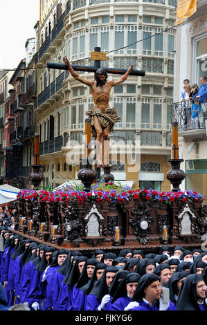 Malaga, Spagna - 18 Aprile 2011: un gruppo di incappucciati portatori (chiamato Costaleros) portante un galleggiante religiosa (noto come Tronos) in t Foto Stock
