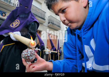 Durante la Semana Santa (Pasqua) processioni in Spagna a Malaga, ai bambini piace raccogliere le sfere di cera formata dalle candele Foto Stock