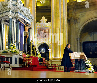Malaga, Spagna - 18 Aprile 2011:Cattolico Romano nun preparando l'altare per il servizio, nella Cattedrale di Malaga, Spagna durante Foto Stock