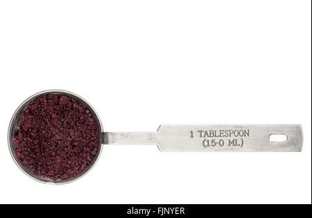 Acai berry in polvere in una misurazione di metallo cucchiaio isolato su bianco Foto Stock