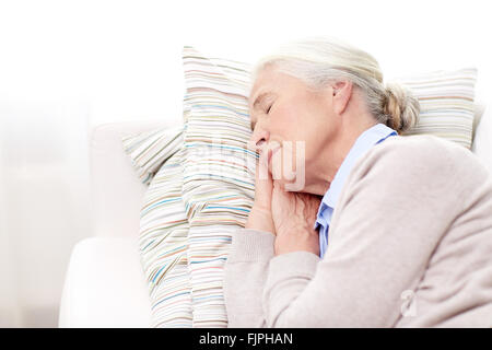 Felice senior donna che dorme sul cuscino a casa Foto Stock