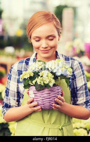 Donna felice profumati fiori in serra Foto Stock