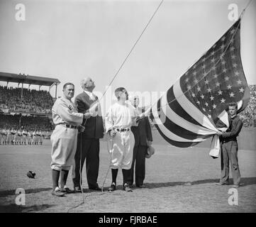 Joe McCarthy, direttore Yankee di New York, il Postmaster generale James A. Farley, il senatore di Washington Bucky Harris, e Clark Griffith, proprietario dei senatori, che elevano la bandiera americana prima della prima partita di baseball della stagione, Griffith Stadium, Washington DC, USA, Harris & Ewing, Aprile 21, 1939 Foto Stock