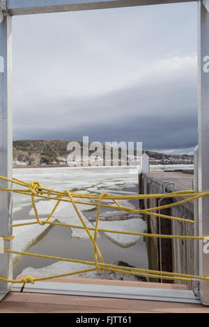 Giallo barriera corda bloccando l'accesso a St Larence fiume che è coperto in grandi blocchi di ghiaccio galleggiante, in Gaspe, Quebec, Cana Foto Stock