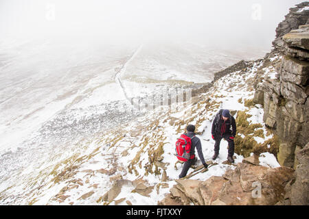 Due escursionisti Climbing Pen Y Gand Hill, nel Yorkshire Dales National Park, Inghilterra Foto Stock