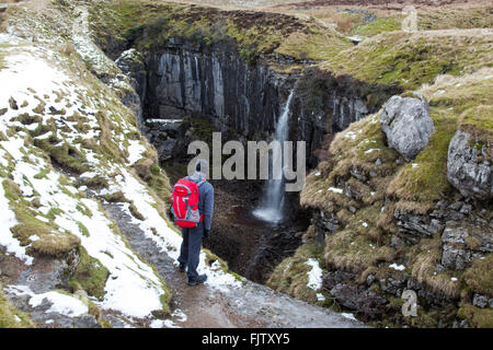 Walker guardando giù nella pentola di scafo Horton in Ribblesdale, Nord, nello Yorkshire, Inghilterra. Foto Stock