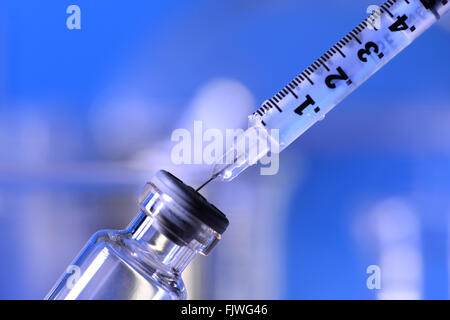 Siringa essendo inserita in una fiala in un laboratorio Foto Stock