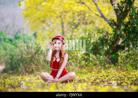 Ritratto di una bella ragazza tra fiori gialli nella natura,thailandia,l'Asia. Foto Stock