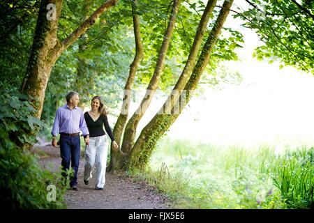 Paio di boschi circondati dalla natura, tenendo le mani Foto Stock