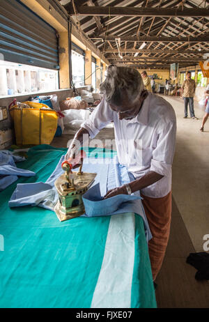 Un uomo che lavora in Kochi Dhobi Wallah Kerala India Foto Stock