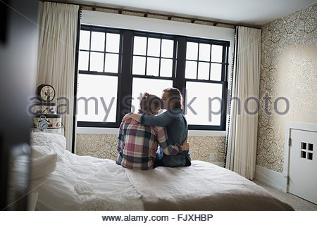 Madre abbracciando e baciando figlia adolescente in camera da letto