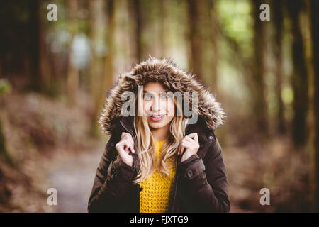 Bella donna bionda che indossa il ponticello con cappuccio Foto Stock
