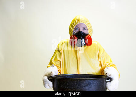 Donna matura in giallo hazmat suit holding teglia. Foto Stock