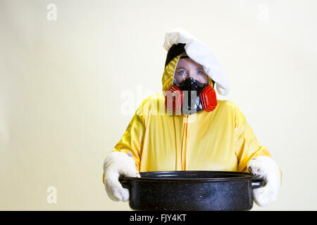 Donna matura in giallo hazmat e chef hat tuta azienda teglia. Foto Stock