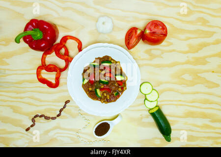 Componenti del peperoncino vegetale decomposto attorno al vaso sul piano portapaziente. Foto Stock