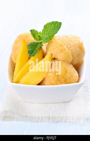 Peach gelato con fette nella ciotola bianco Foto Stock