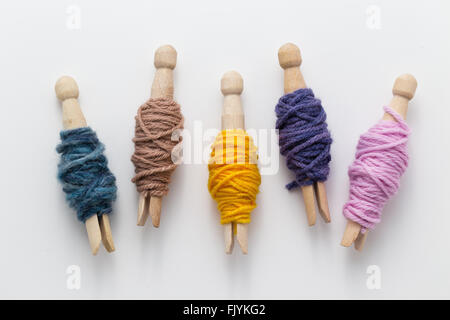 Avvolto piccoli scarti di filato attorno clothespins Foto Stock