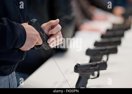 Norimberga, Germania. Mar 4, 2016. Un visitatore in possesso di una pistola del costruttore tedesco Walther alla caccia e armi sportive fair IWA OutdoorClassics in Nuremberg, Germania, 4 marzo 2016. All'IWA, oltre 1400 espositori presentano caccia e sport armi, munizioni, coltelli, outdoor gadget e accessori. Foto: DANIEL KARMANN/dpa/Alamy Live News Foto Stock