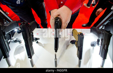 Norimberga, Germania. Mar 4, 2016. Un visitatore in possesso di una pistola del costruttore tedesco Heckler und Koch alla caccia e armi sportive fair IWA OutdoorClassics in Nuremberg, Germania, 4 marzo 2016. All'IWA, oltre 1400 espositori presentano caccia e sport armi, munizioni, coltelli, outdoor gadget e accessori. Foto: DANIEL KARMANN/dpa/Alamy Live News Foto Stock