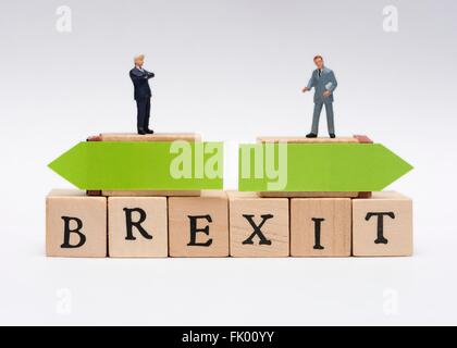 Business in miniatura di uomini in abiti permanente sulla parte superiore della parola Brexit con opposte frecce verdi Nozione di decisione Foto Stock