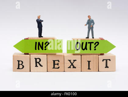 Business in miniatura che indossa abiti permanente sulla sommità del Brexit in o fuori del concetto. Foto Stock