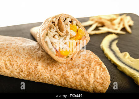 Avvolgimento sandwich o Tortilla con avanzi di carne, formaggio e carne di maiale mais nero sul tagliere su bianco. Gustosi piatti Fast Food messicano, Foto Stock