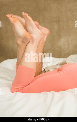 In prossimità dei piedi di carino coppia giacendo in letto Foto Stock