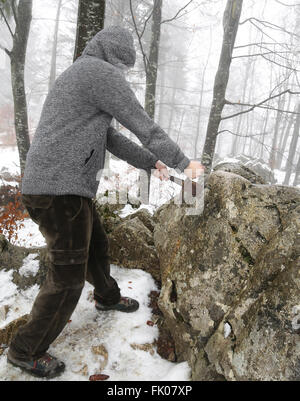 Valoroso cavaliere anonimo rimuove l'Excalibur magica spada nella roccia Foto Stock