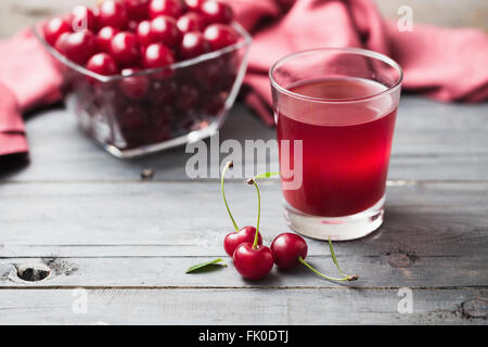 Bicchiere di succo di ciliegia con ciliegie acide fresche Foto Stock