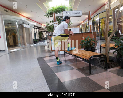 Un giovane uomo attende in una quasi vuoto mall in Massachusetts. Foto Stock