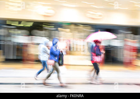 Una shopper oltrepassando un negozio finestra, Shopping Spree Foto Stock