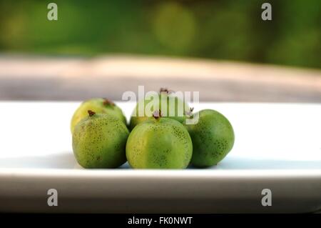 Baby kiwi bacche " actinidia arguta' su un tavolo di legno Foto Stock