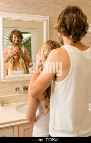 Uomo bello che copre la sua ragazza occhi Foto Stock