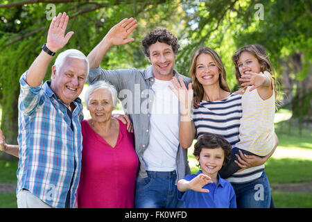 Famiglia sorridente sventolare le mani Foto Stock