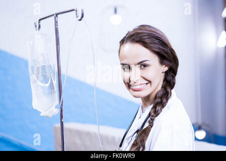 Ritratto di medico donna portando la soluzione salina stand Foto Stock