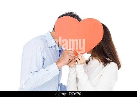 Coppia adorabile kissing dietro un grande cuore Foto Stock