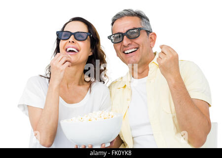 Coppia sorridente con gli occhiali 3D mangiare popcorn Foto Stock