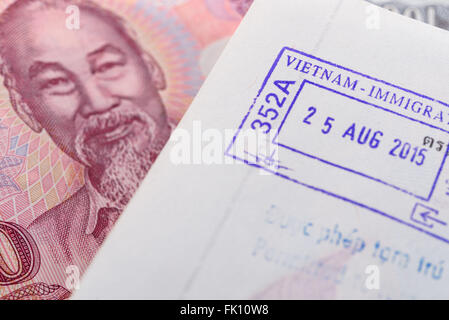 Visa timbro apposto sul passaporto dal Vietnam e denaro vietnamita (Dong) Foto Stock