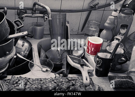 Pila di sporco utensili in cucina un lavabo e una tazza di colore rosso con un Ti Amo testo Foto Stock