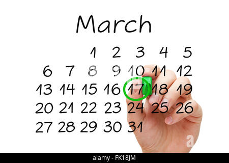 Mettendo mano contrassegnare il 17 marzo sul calendario con contrassegno verde sul panno trasparente stampato. Saint Patricks giorno concetto. Foto Stock