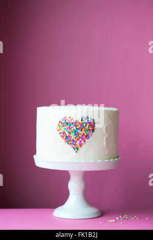 Cuore la torta su un sfondo rosa Foto Stock
