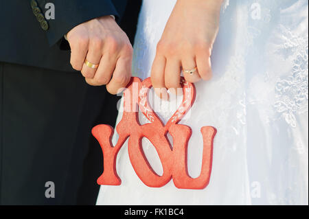 Cartello in legno ti amo nelle mani del giovane Foto Stock