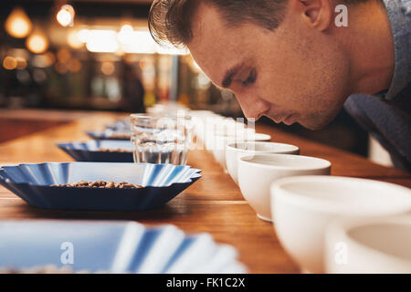 L'Uomo odore di caffè aromatico presso una degustazione Foto Stock