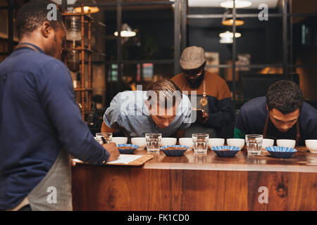 Barista training con righe di diversi caffè in roastery Foto Stock