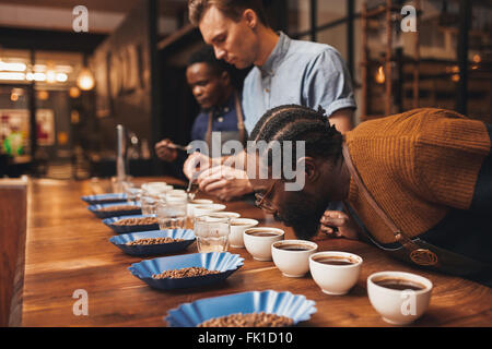 Formazione baristi con varietà di chicchi di caffè nella moderna tostatore Foto Stock